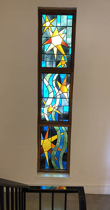 The 1975 window is located near the stairs of Cowell faculty offices closest to room 106.